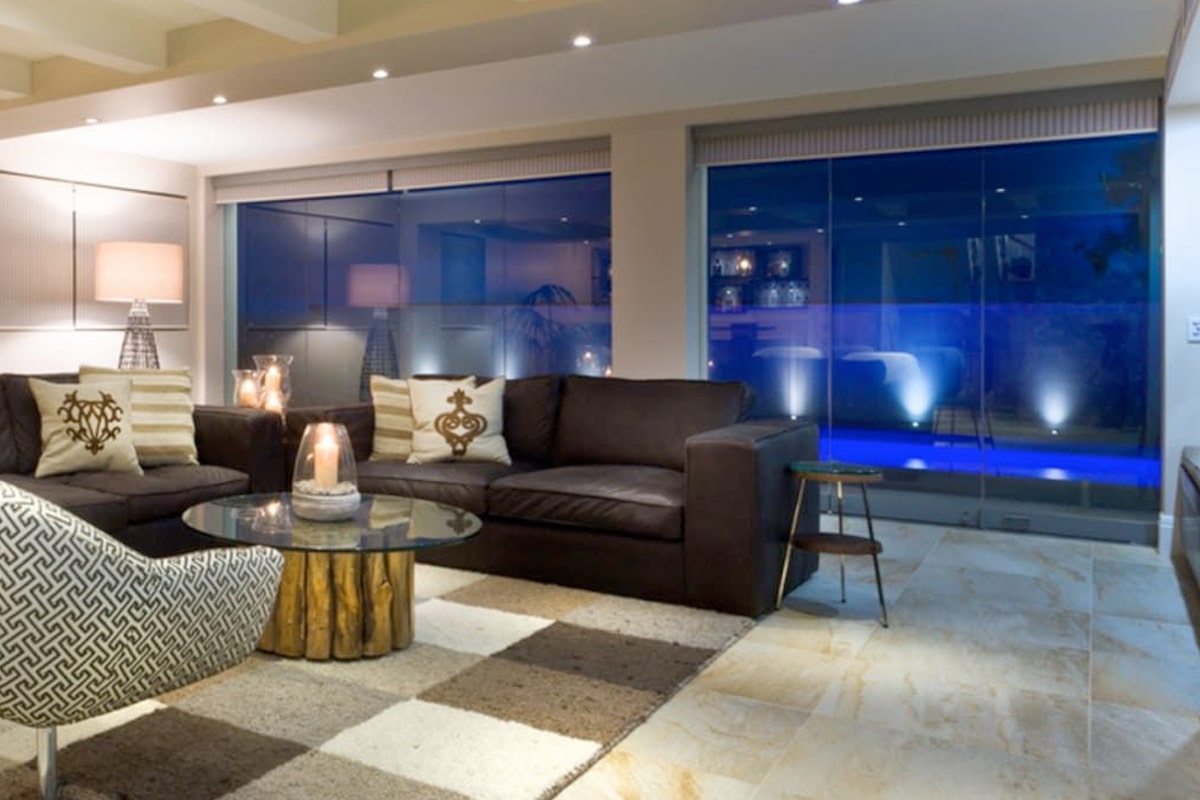 Una sala de estar con una gran pared de vidrio y una piscina.