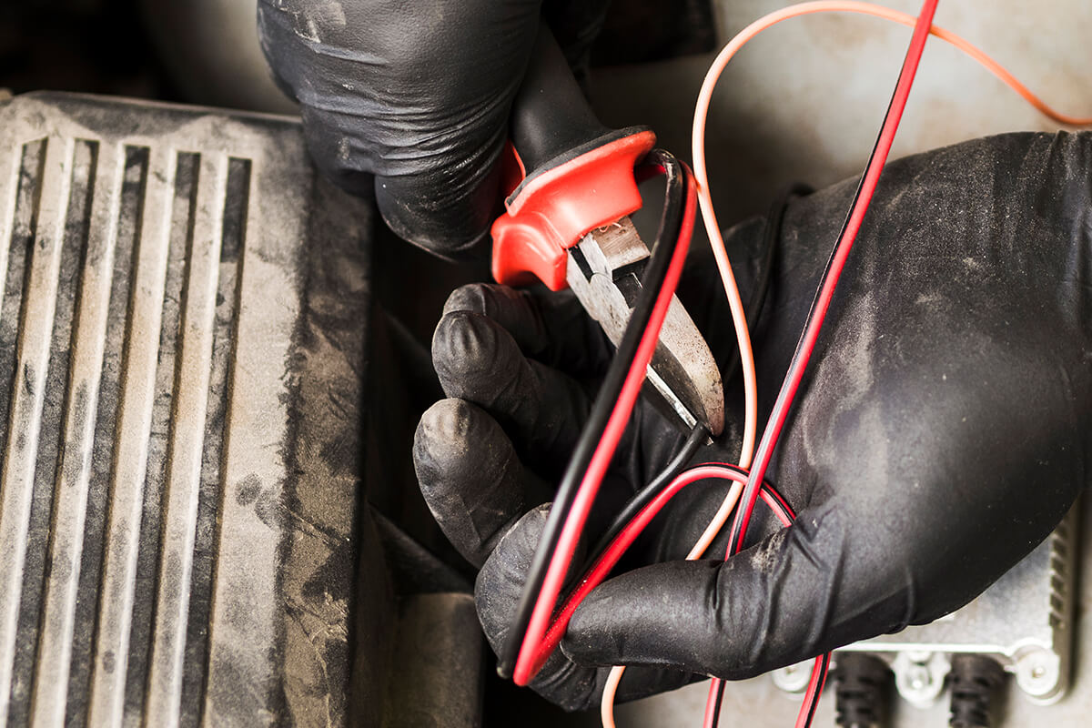 Una persona con guantes negros sostiene unas pinzas.