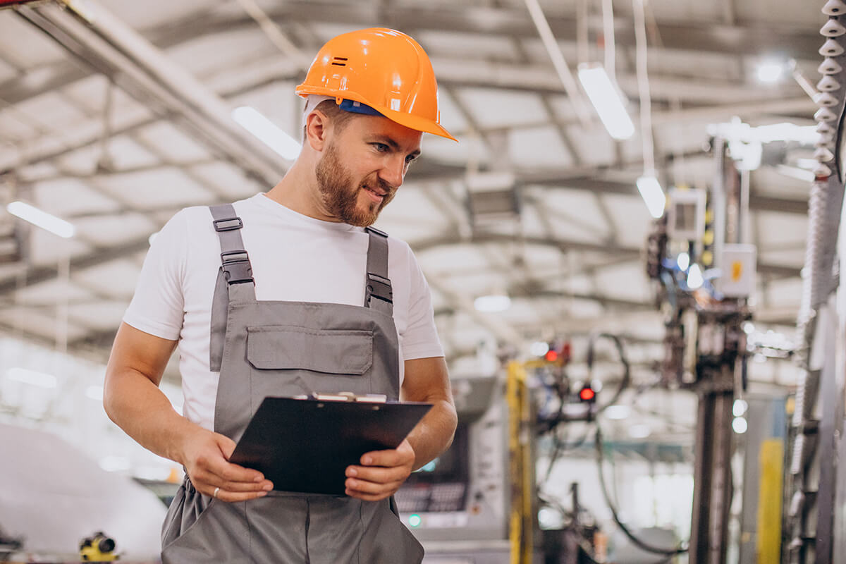 n hombre con overol sosteniendo una tabla de registro.