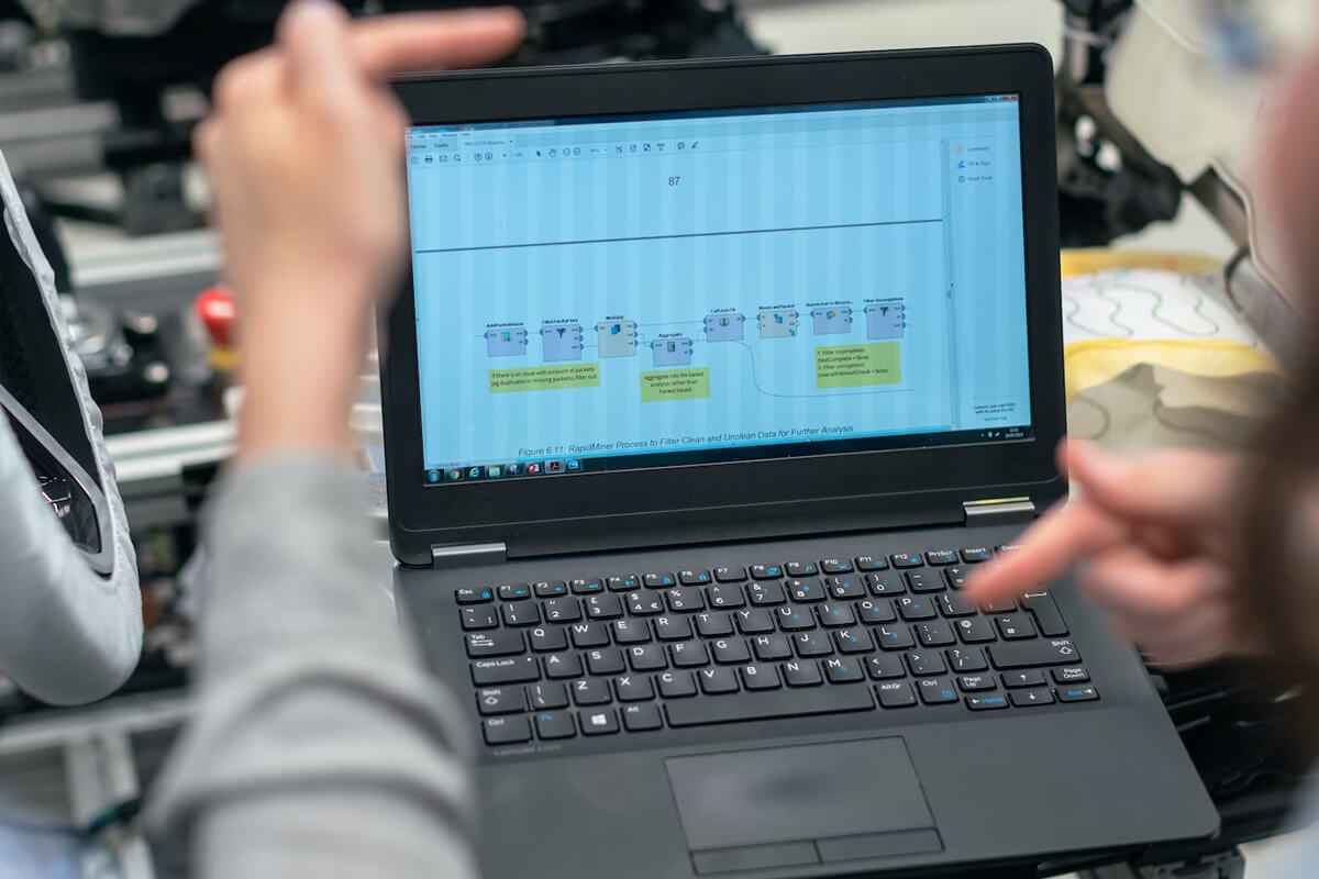 Persona señalando la pantalla de una laptop.